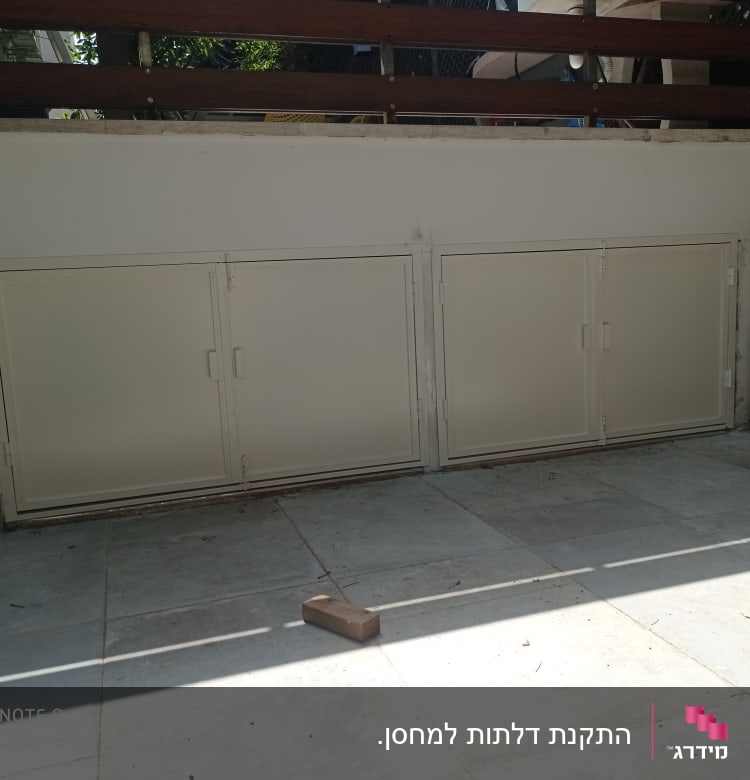 שלוש דלתות מתכת לבנות עם מסגרות על קיר חיצוני